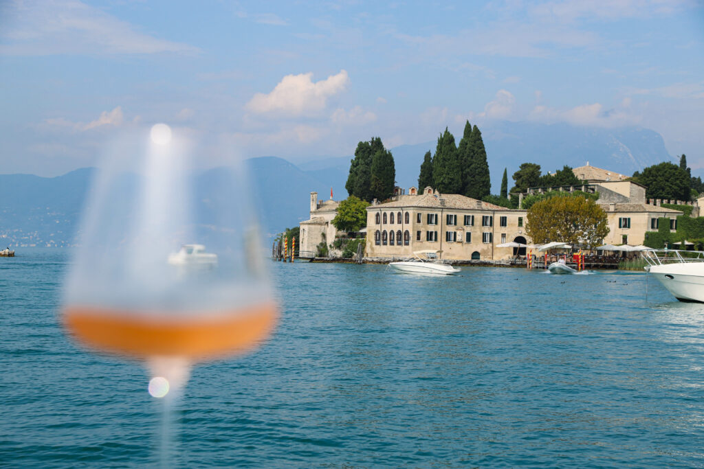 A glass of wine with backgroud of Garda Lake